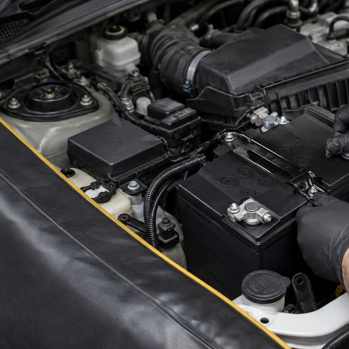 Technician fitting an AGM car battery before battery registration